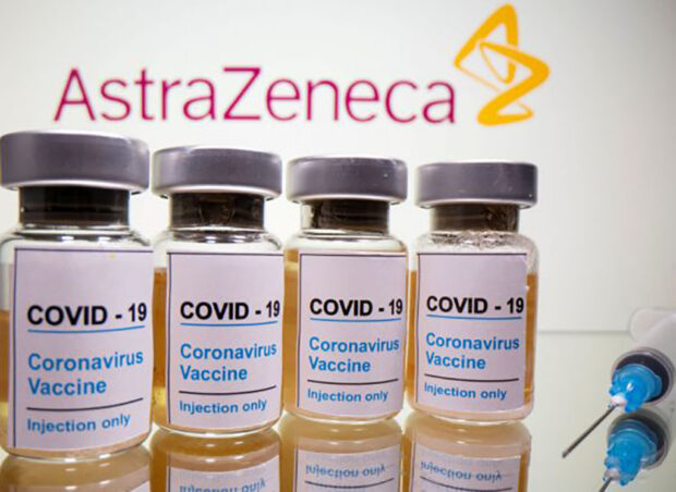 FILE PHOTO: FILE PHOTO: Vials and medical syringe are seen in front of AstraZeneca logo in this illustration